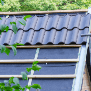 roofing companies near me - The Benefits of Hiring a Professional Roofing Contractor for Your Roofing Project - a partially tiled roof with a tree branch nearby