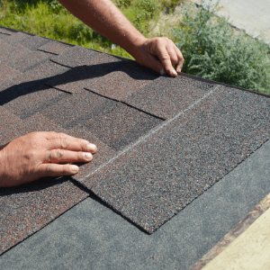 absolute quality roof restoration - Roof Restoration What to Expect When Choosing Roofing Johnson City - a pair of hands installing asphalt shingle roofing