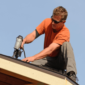 roofing companies Kingsport TN - The Services Roofing Companies in Kingsport TN Provide - a roofer with his nail gun working on a roof