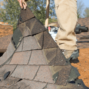 roofing companies in johnson city tn - DIY Roof Replacement vs. Professional Roofing Replacement Which is Right For You - a roofer tearing down old and worn out asphalt roof from a house